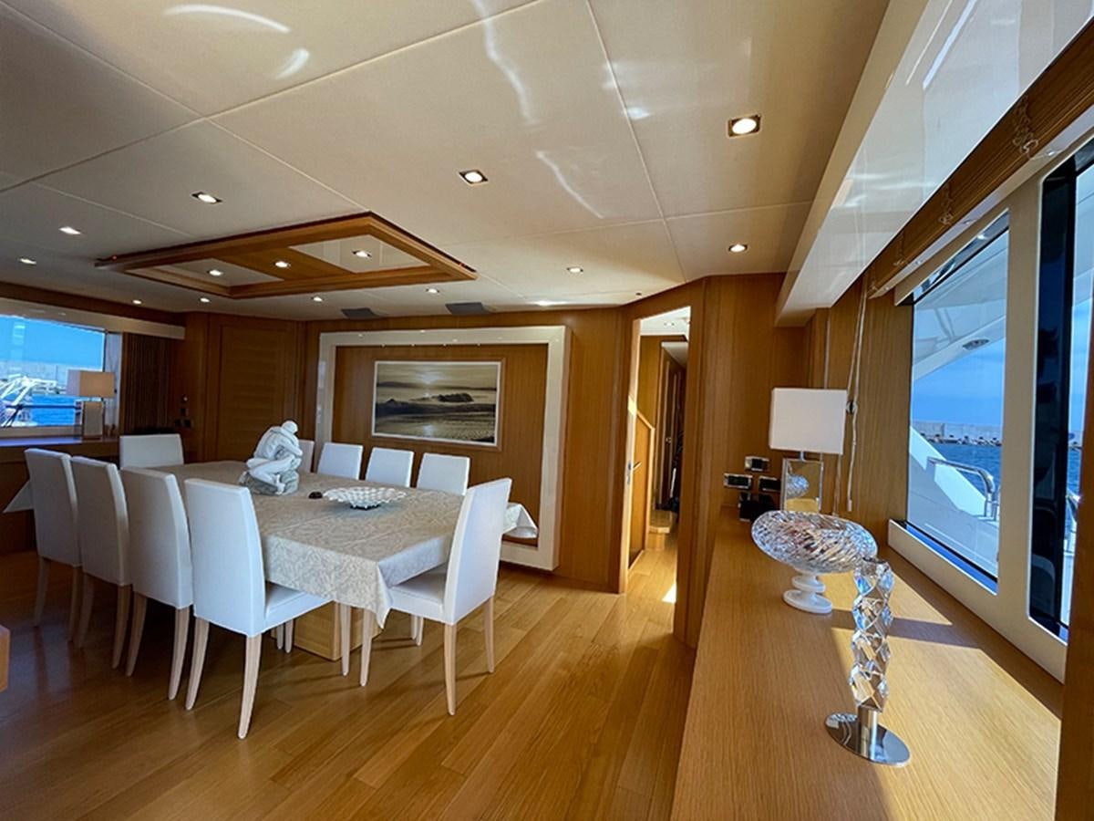a room with tables and chairs aboard EVIL ZANA Yacht for Sale
