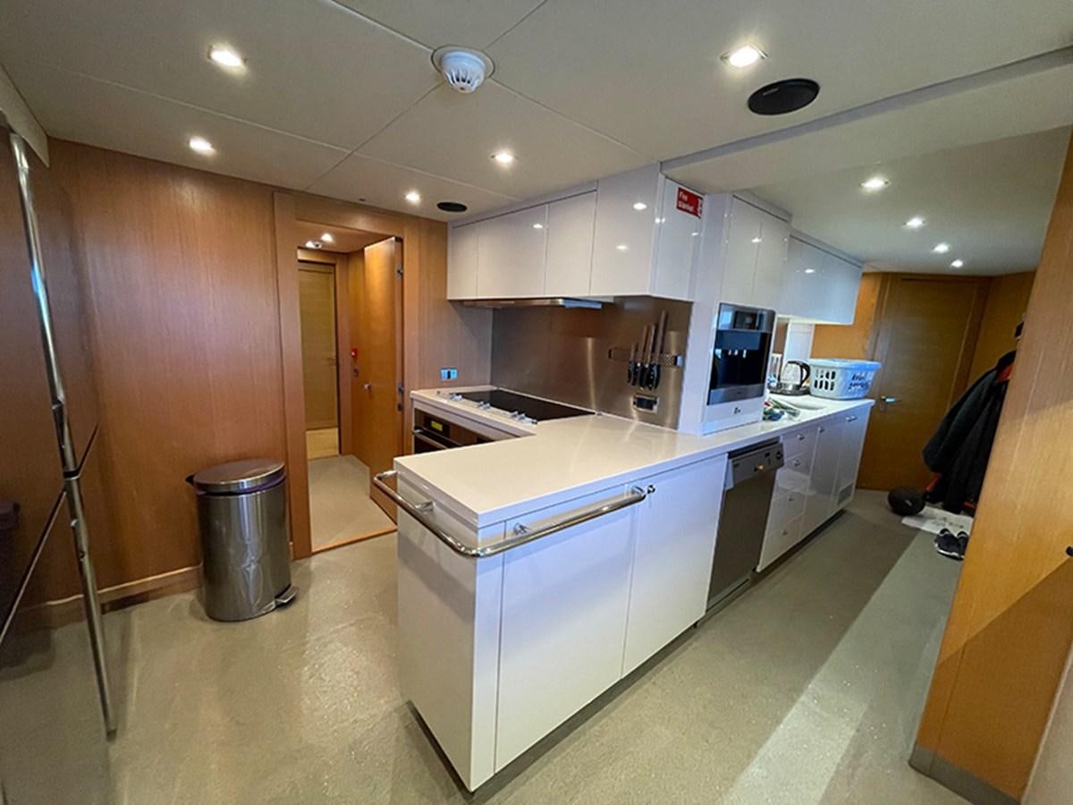 a kitchen with a large island aboard EVIL ZANA Yacht for Sale