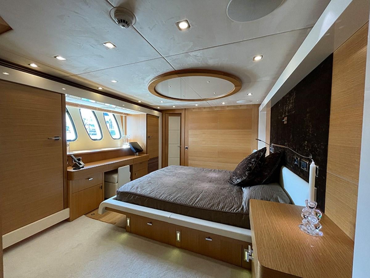 a bedroom with a bed and desk aboard EVIL ZANA Yacht for Sale