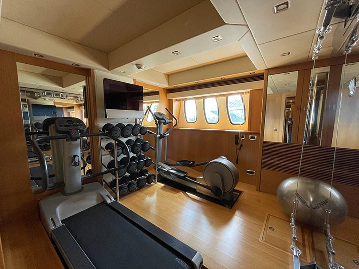 a room with a bar and stools and a large mirror aboard EVIL ZANA Yacht for Sale