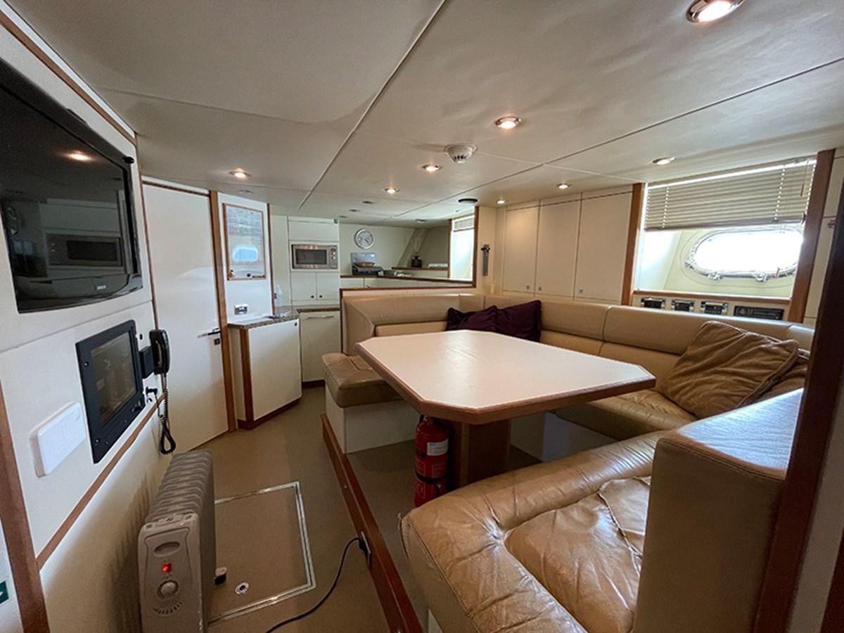 a living room with a couch and a television aboard EVIL ZANA Yacht for Sale