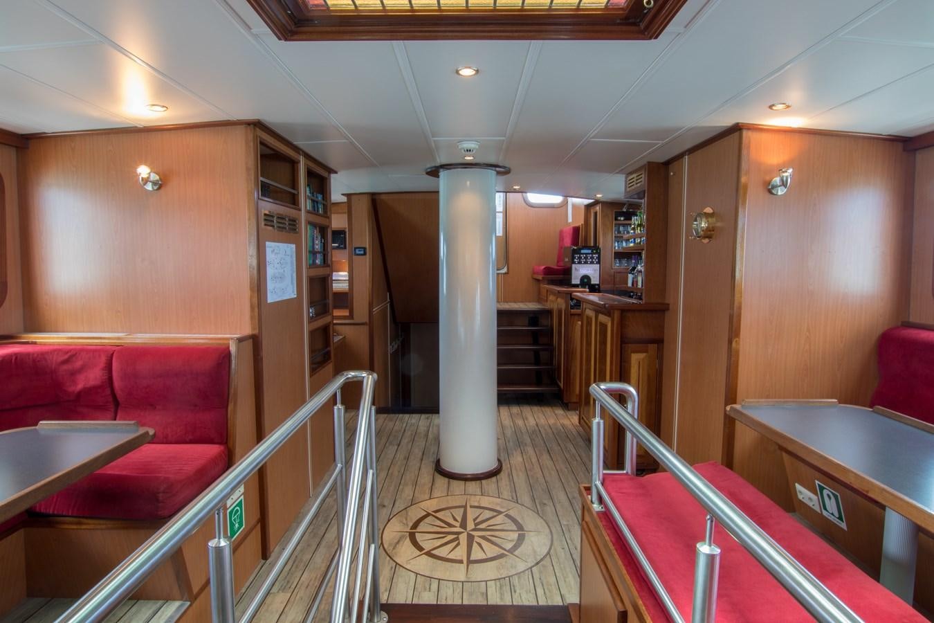 a room with a red couch and a wood door aboard ELDORADO Yacht for Sale