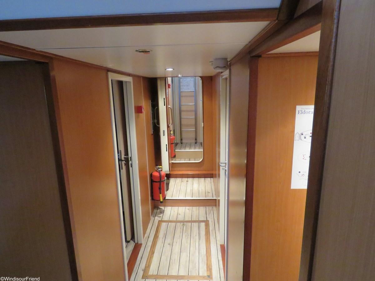a hallway with doors and a red suitcase on the floor aboard ELDORADO Yacht for Sale
