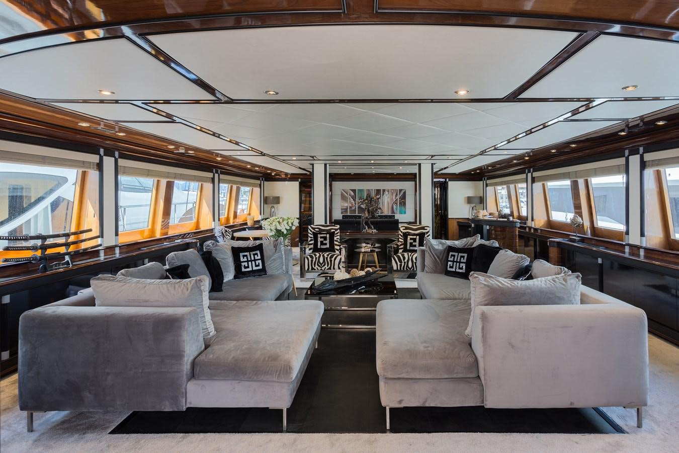 a living room with couches and a large window aboard INDIGO STAR I Yacht for Charter