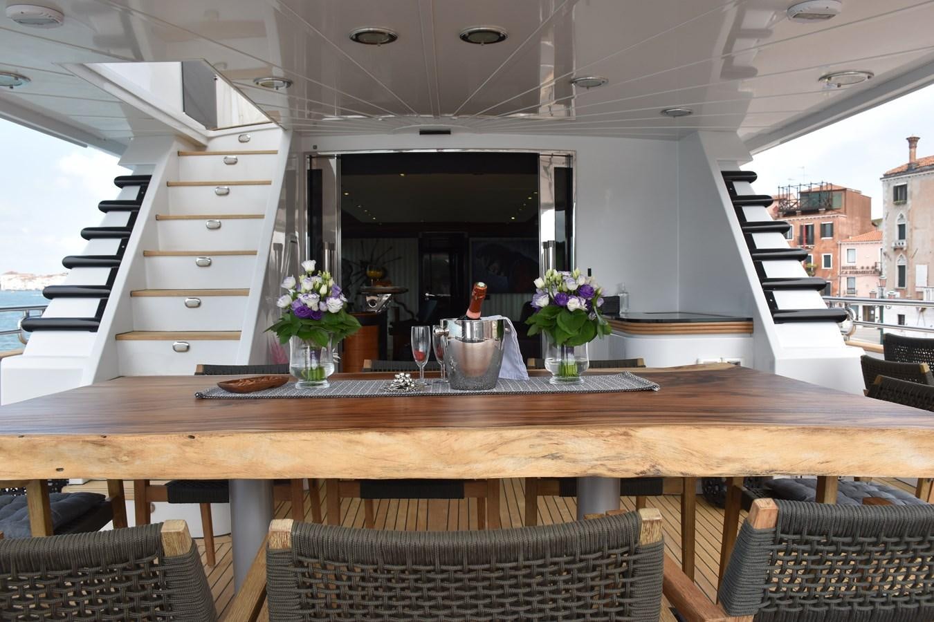 a table with chairs and a couple of vases on it aboard INDIGO STAR I Yacht for Charter