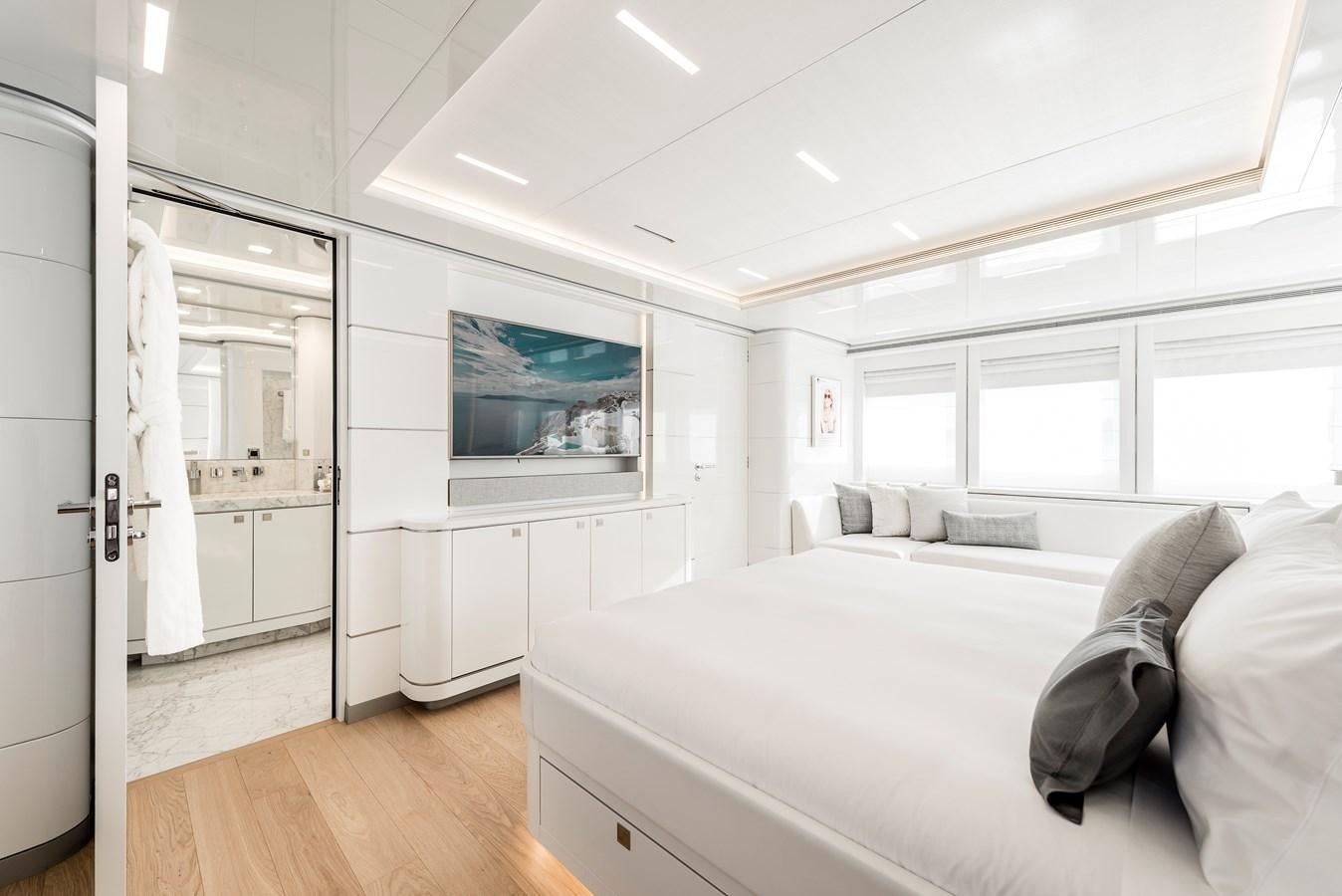 a bedroom with a bed and a tv on the wall aboard ANGKALIA Yacht for Sale