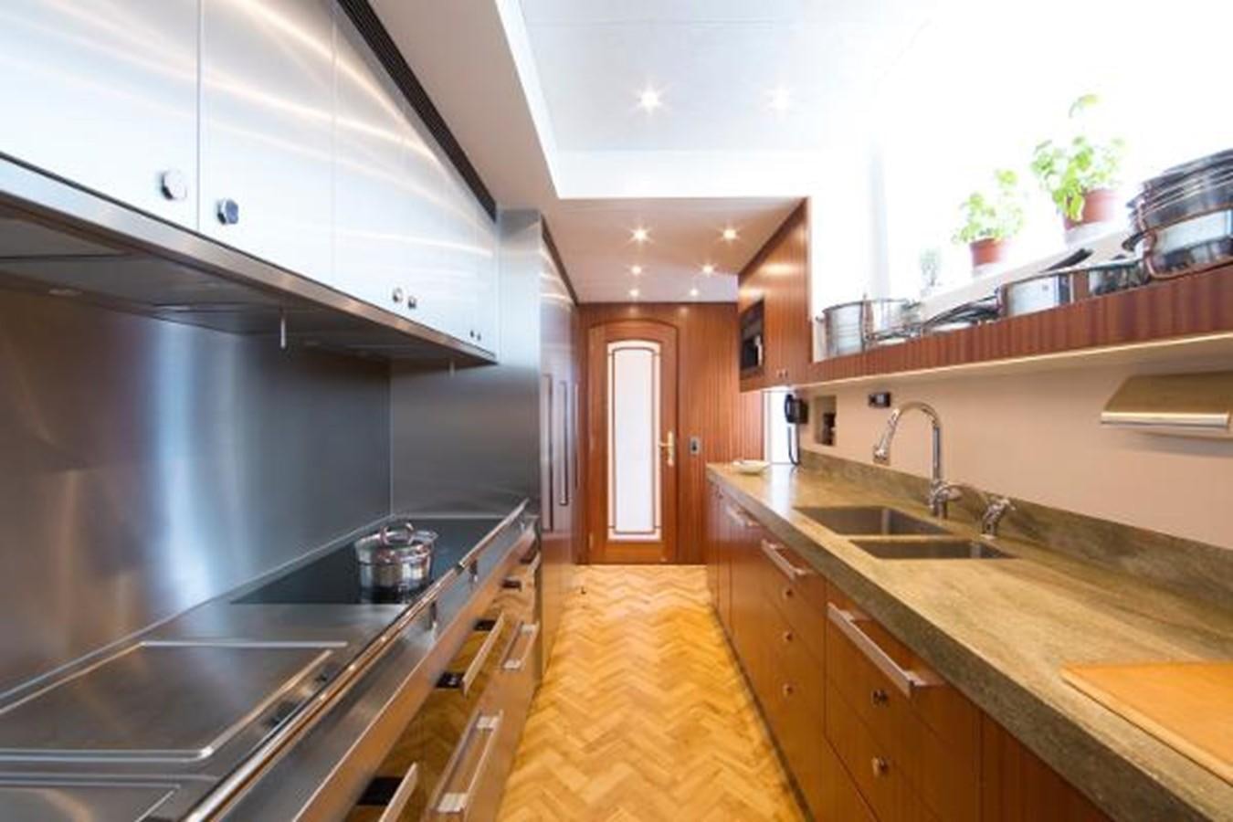 a kitchen with wooden cabinets aboard 121FT EXPLORER 37 Yacht for Sale