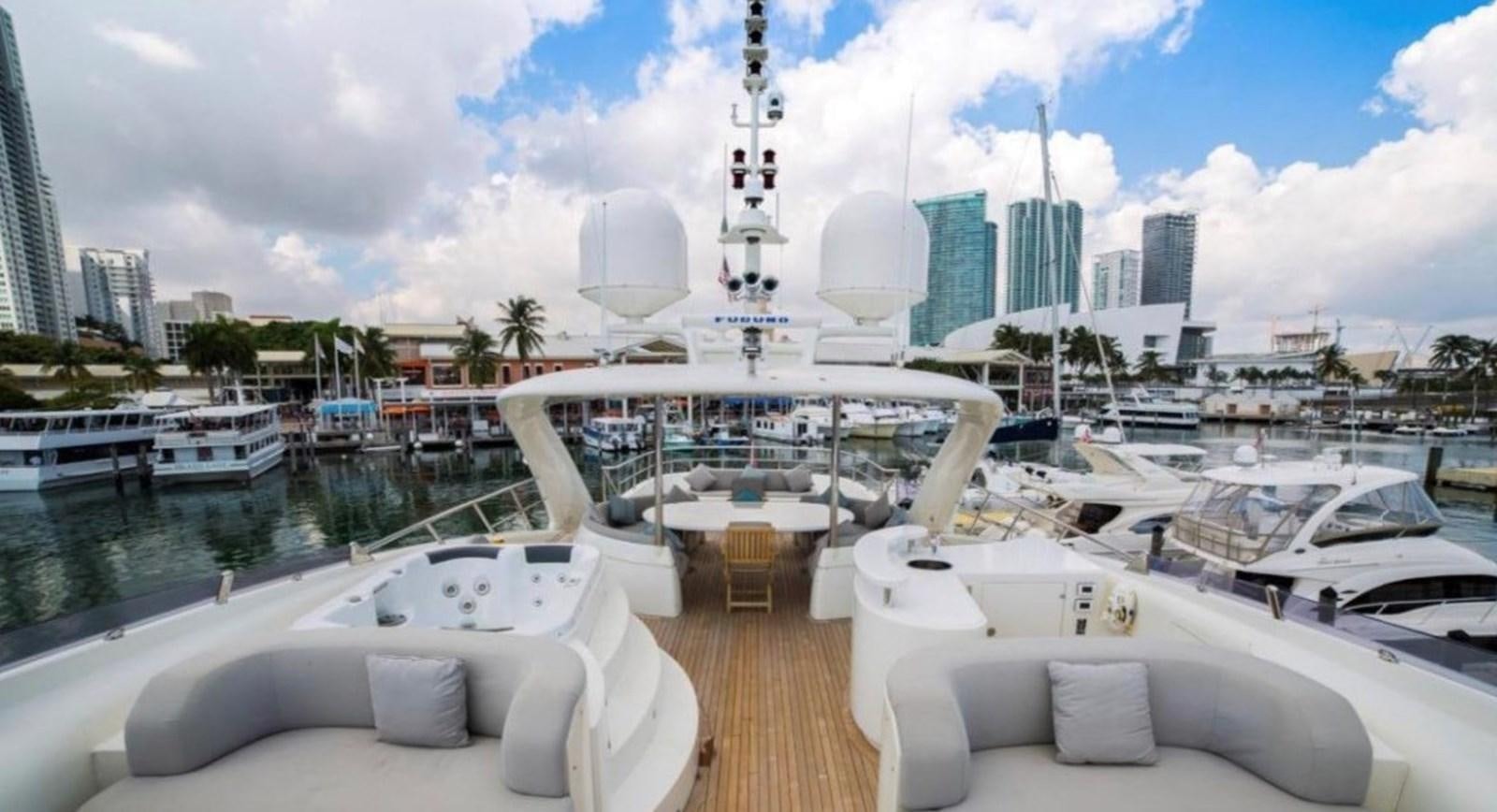 a large white boat in a harbor aboard HAPPY HOUR Yacht for Sale