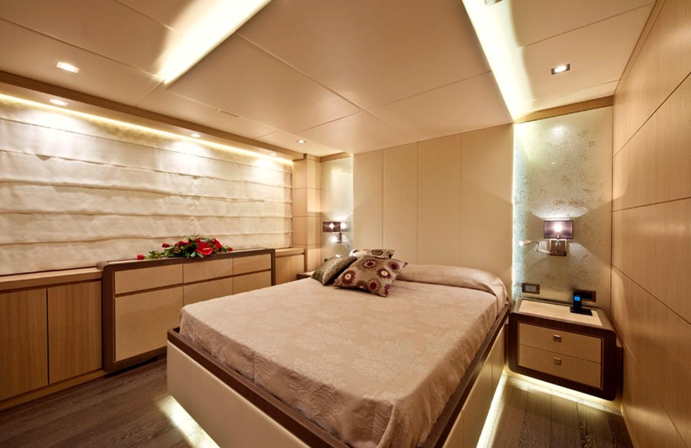 a bedroom with a bed and a desk aboard MUSA Yacht for Sale