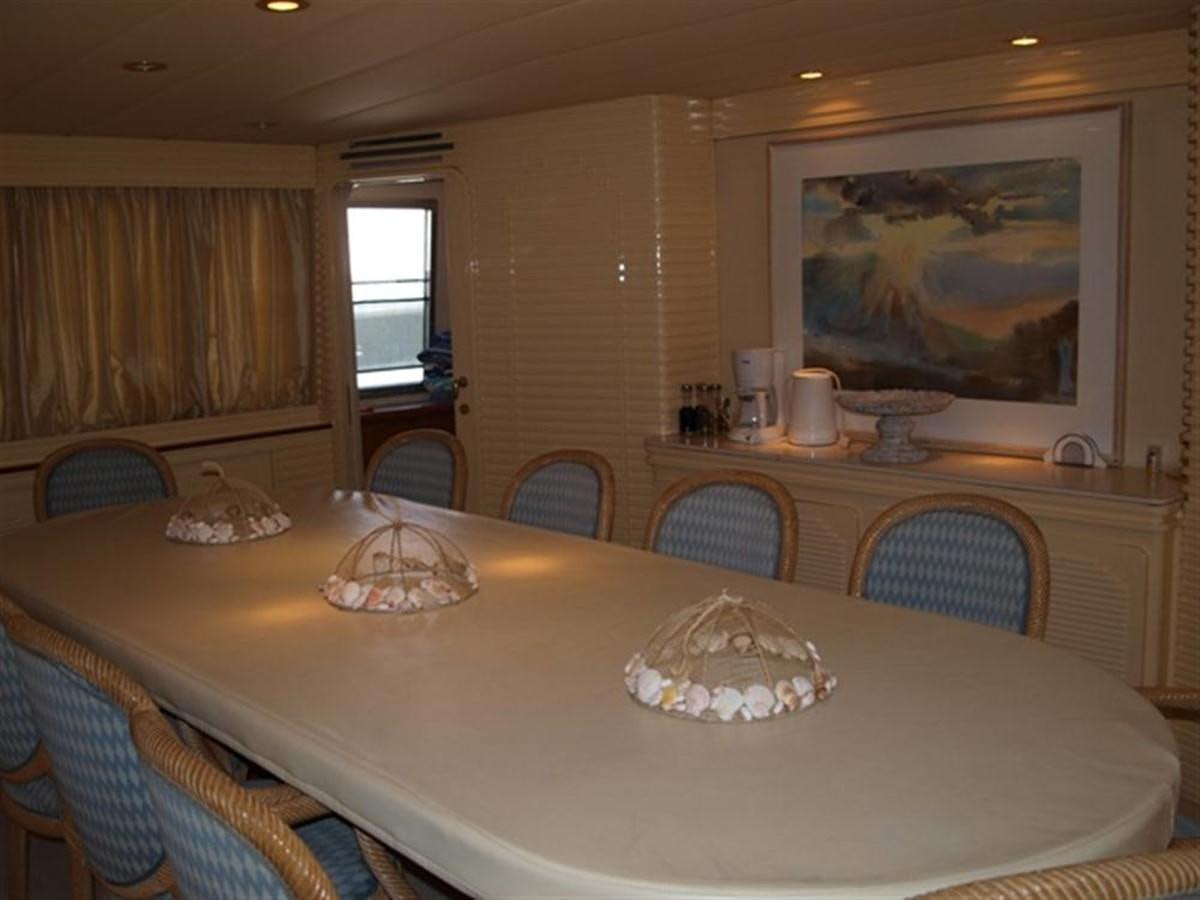 a dining table with a large painting aboard PARADIS Yacht for Sale
