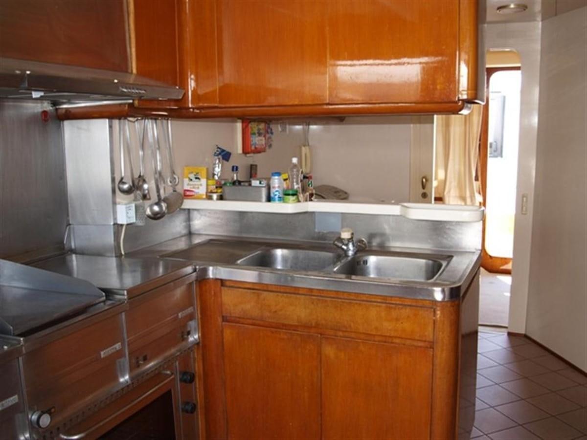 a kitchen with wooden cabinets aboard PARADIS Yacht for Sale
