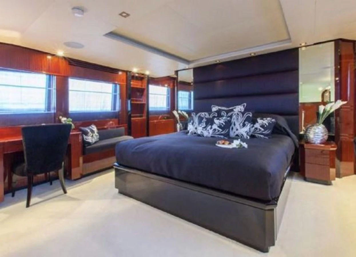 a bedroom with a blue bed aboard ISA 120 Yacht for Sale