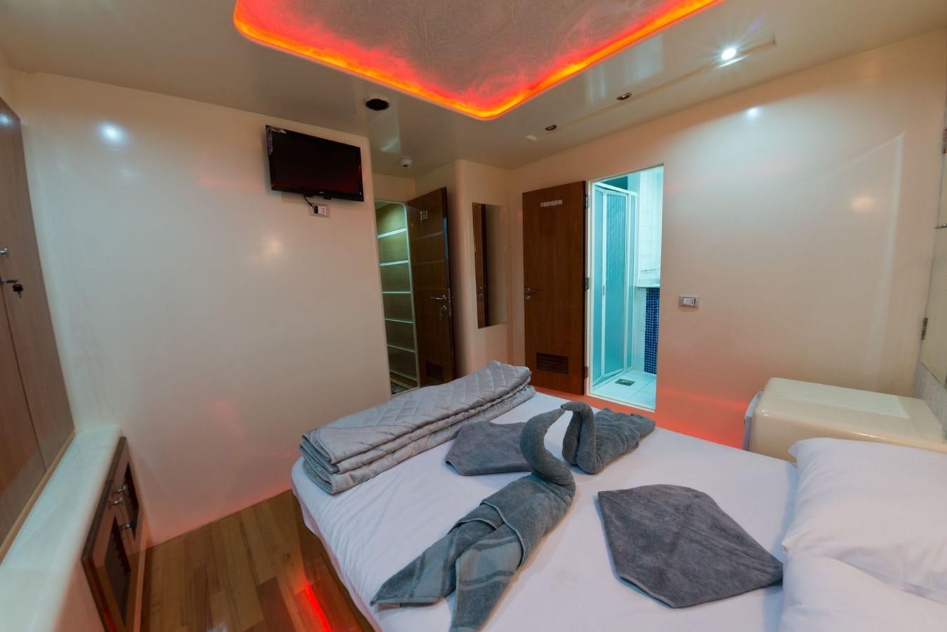 a bedroom with a bed and a television aboard BETELGUESER Yacht for Sale
