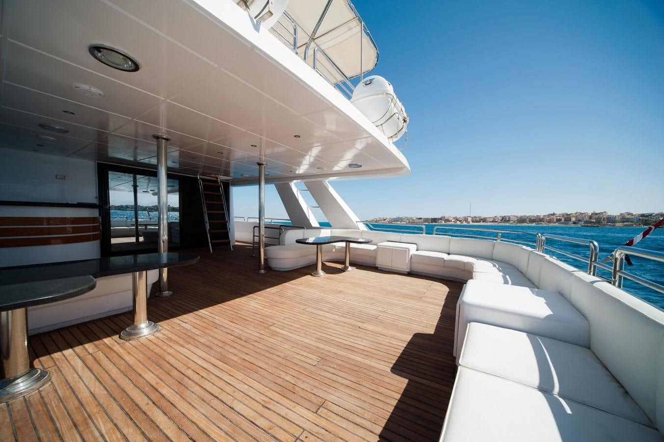 a deck with a pool and a large building with a slide aboard BETELGUESER Yacht for Sale
