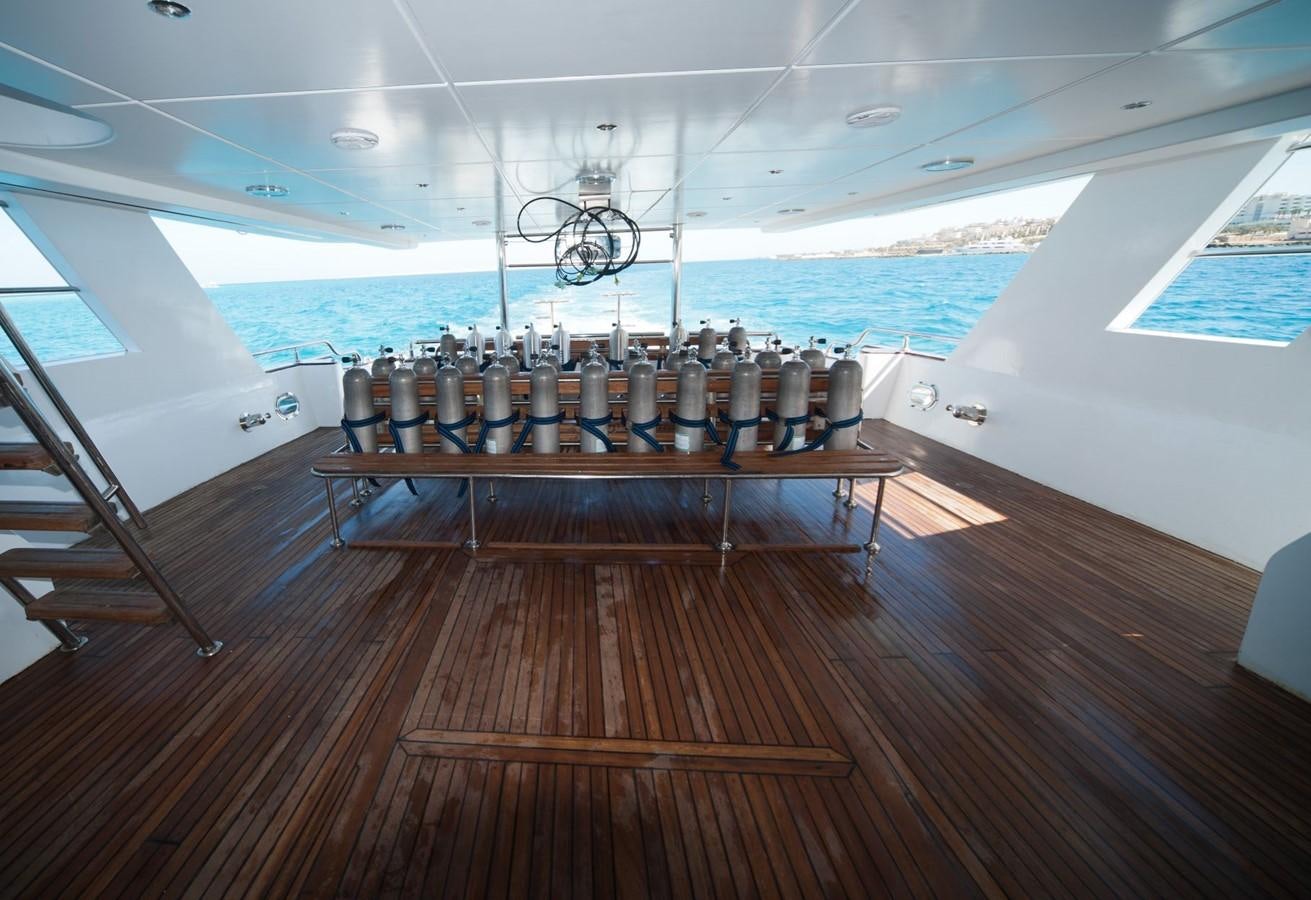 a deck with a large ship in the water aboard BETELGUESER Yacht for Sale