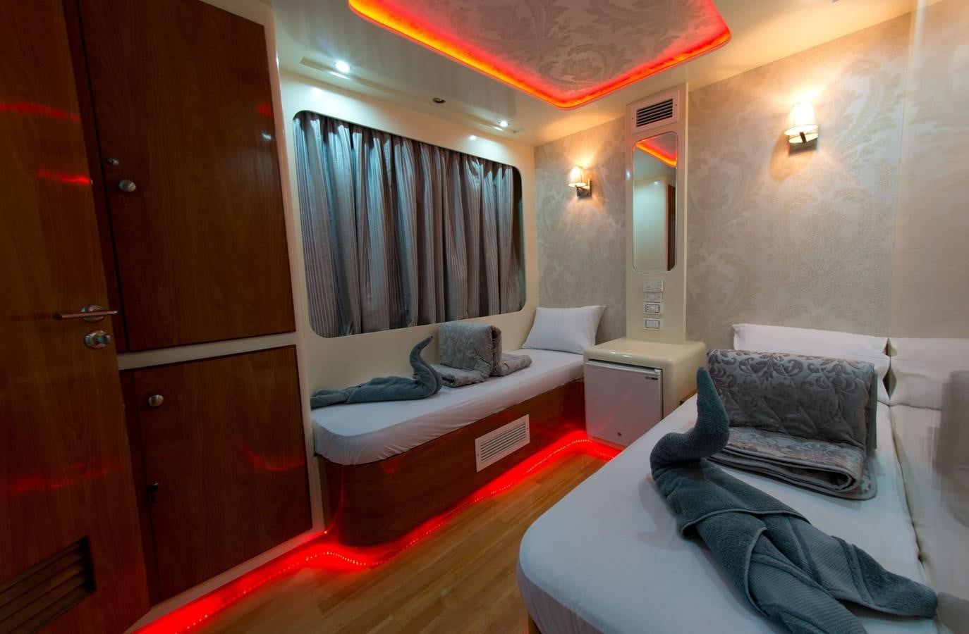 a room with a bed and a desk aboard BETELGUESER Yacht for Sale