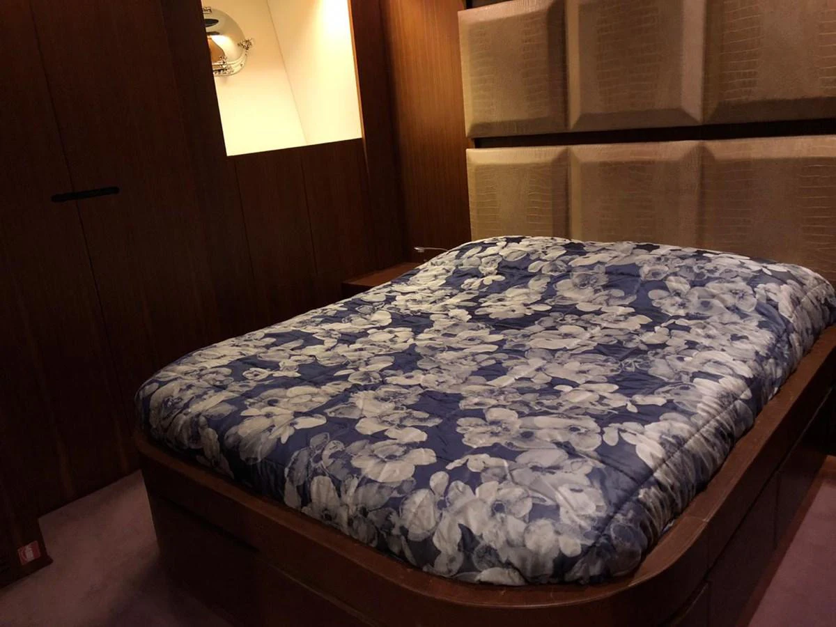a bed with a blue sheet aboard GINEVRA Yacht for Charter