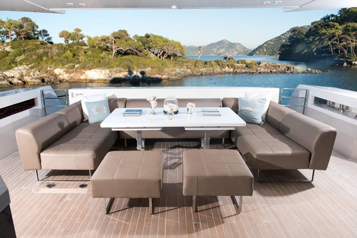 a table and chairs on a deck overlooking a body of water aboard SUN Yacht for Sale