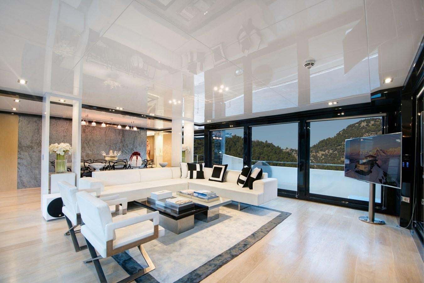 a room with a large window and a large table with chairs aboard SUN Yacht for Sale