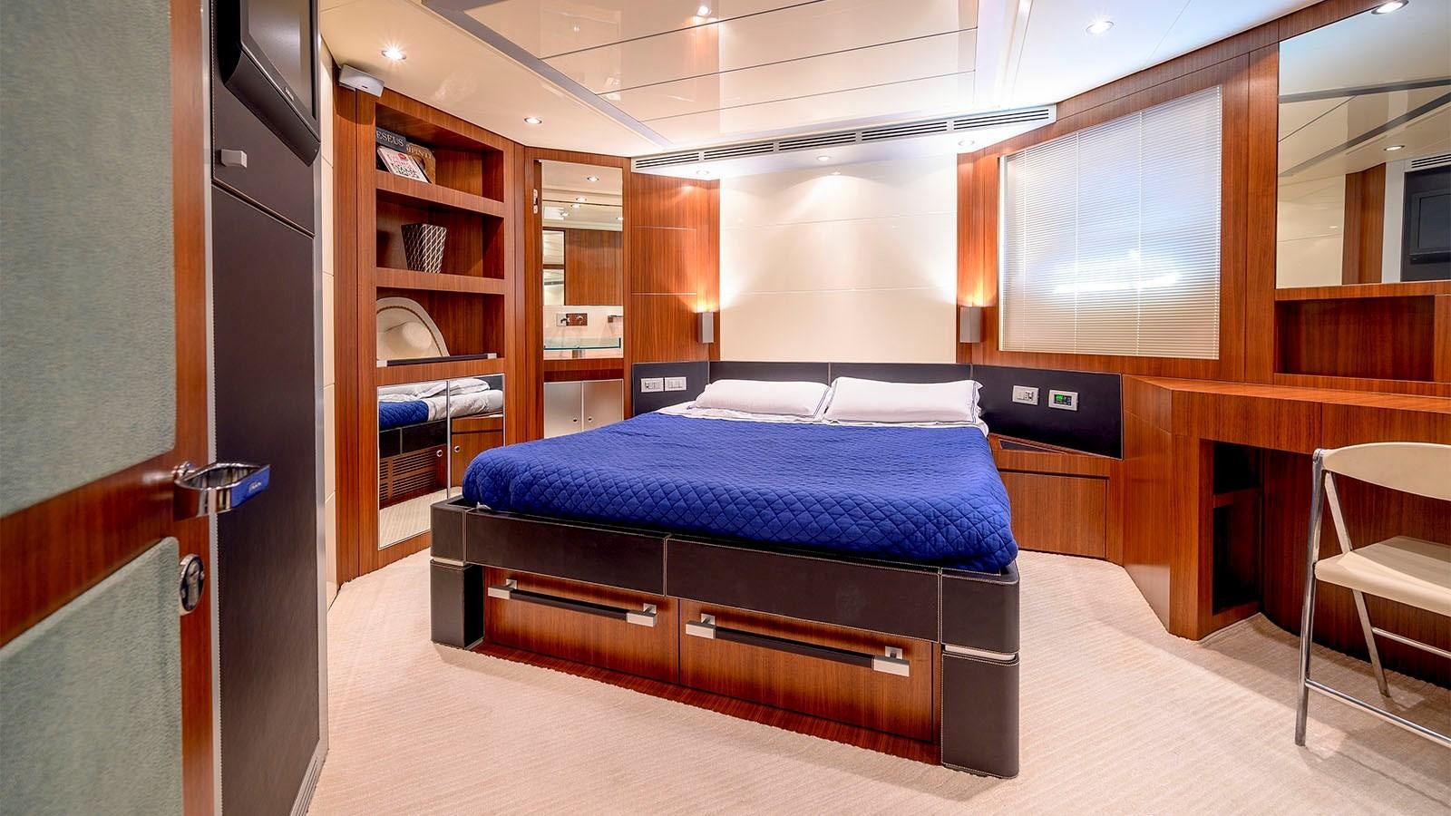 a bedroom with a bed and a desk aboard BEYOND Yacht for Sale
