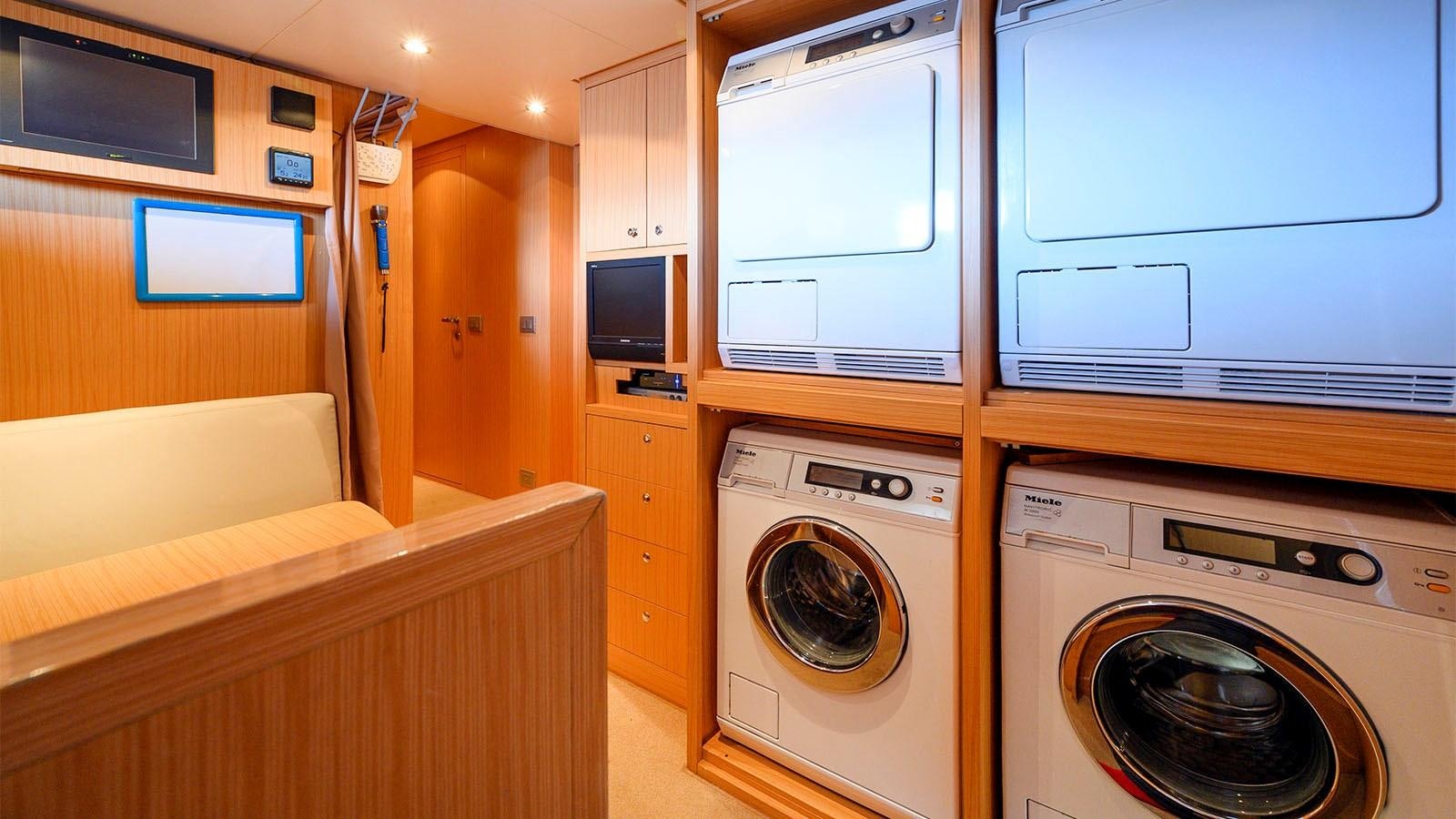 a room with a bed and a washing machine aboard BEYOND Yacht for Sale