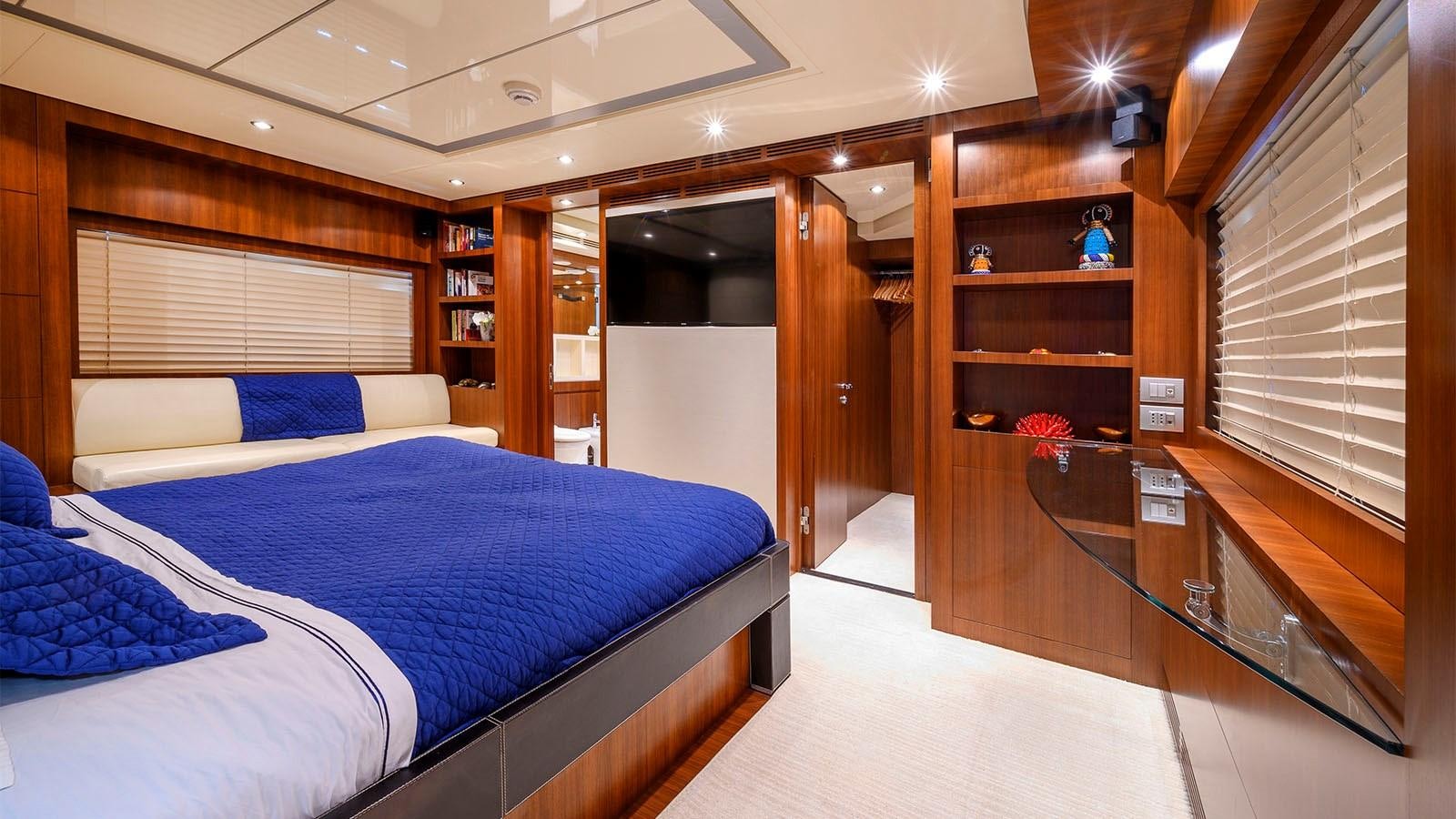 a room with a bed and a shelf with books aboard BEYOND Yacht for Sale