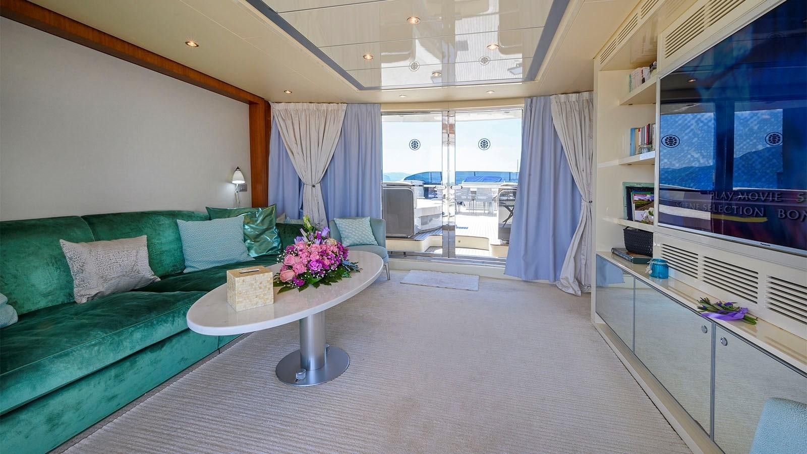 a living room with a green couch aboard BEYOND Yacht for Sale