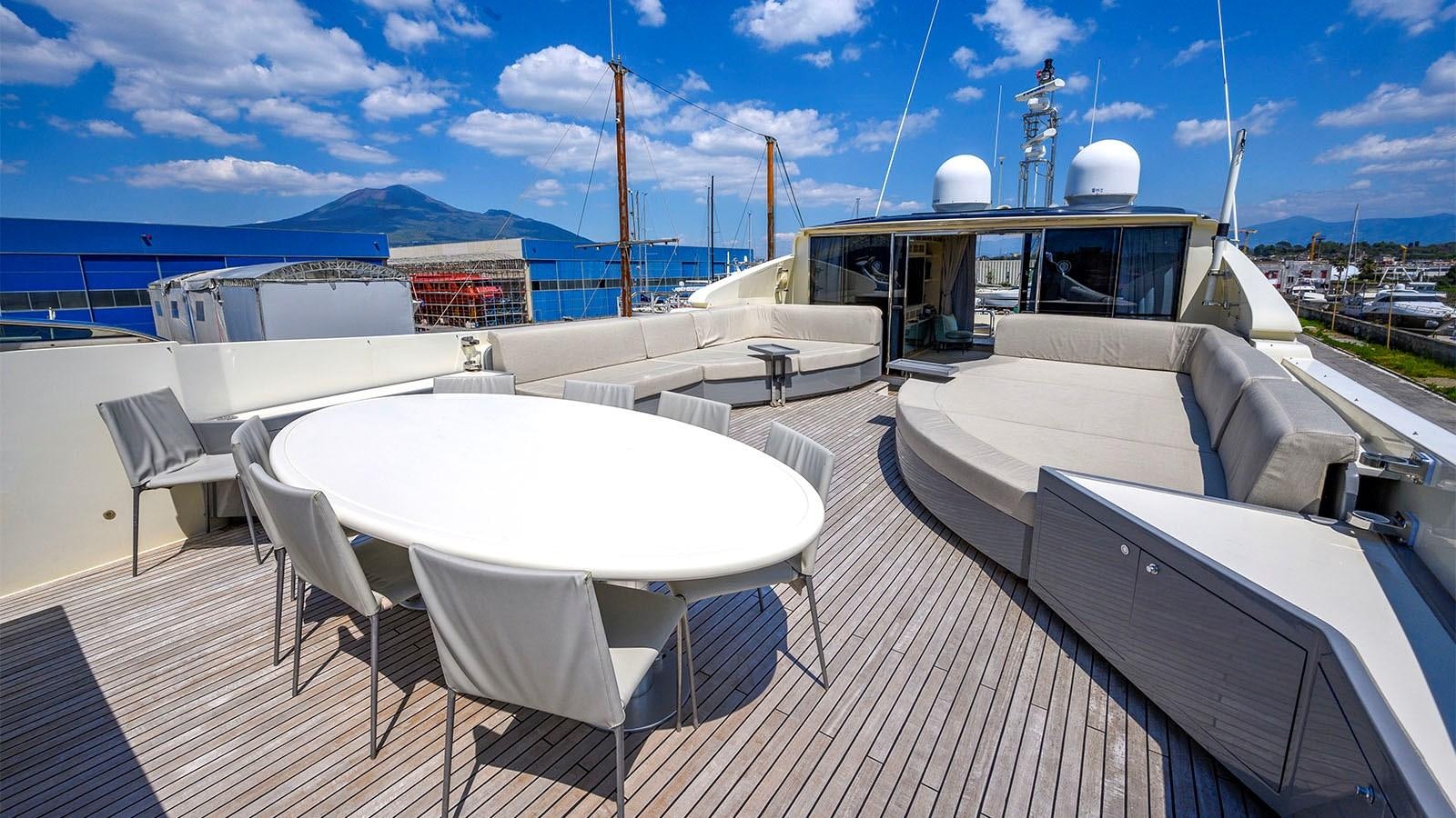 a deck with chairs and tables on it aboard BEYOND Yacht for Sale