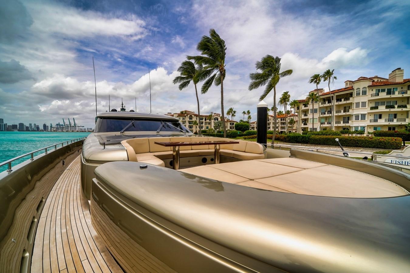 a boat on a deck by a beach and buildings aboard DIAMOND Yacht for Sale