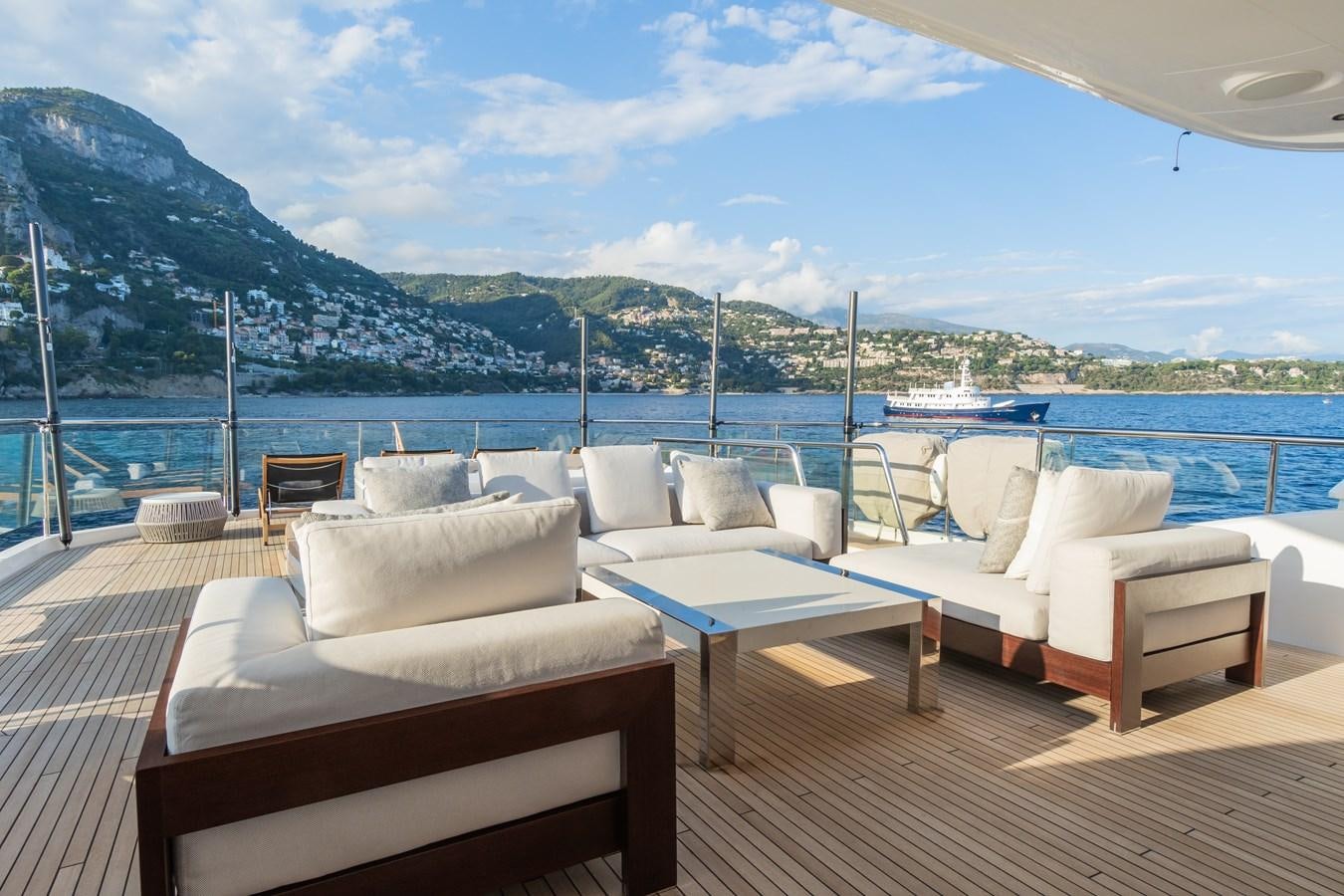 a deck with chairs and a view of a mountain range aboard MINOR FAMILY AFFAIR Yacht for Sale