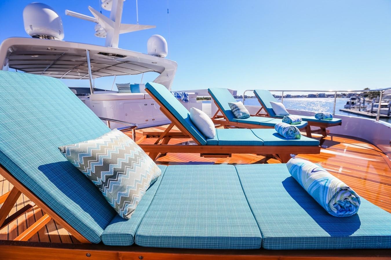 a deck with solar panels and a pool with a building and a boat in the background aboard HUNTER Yacht for Sale