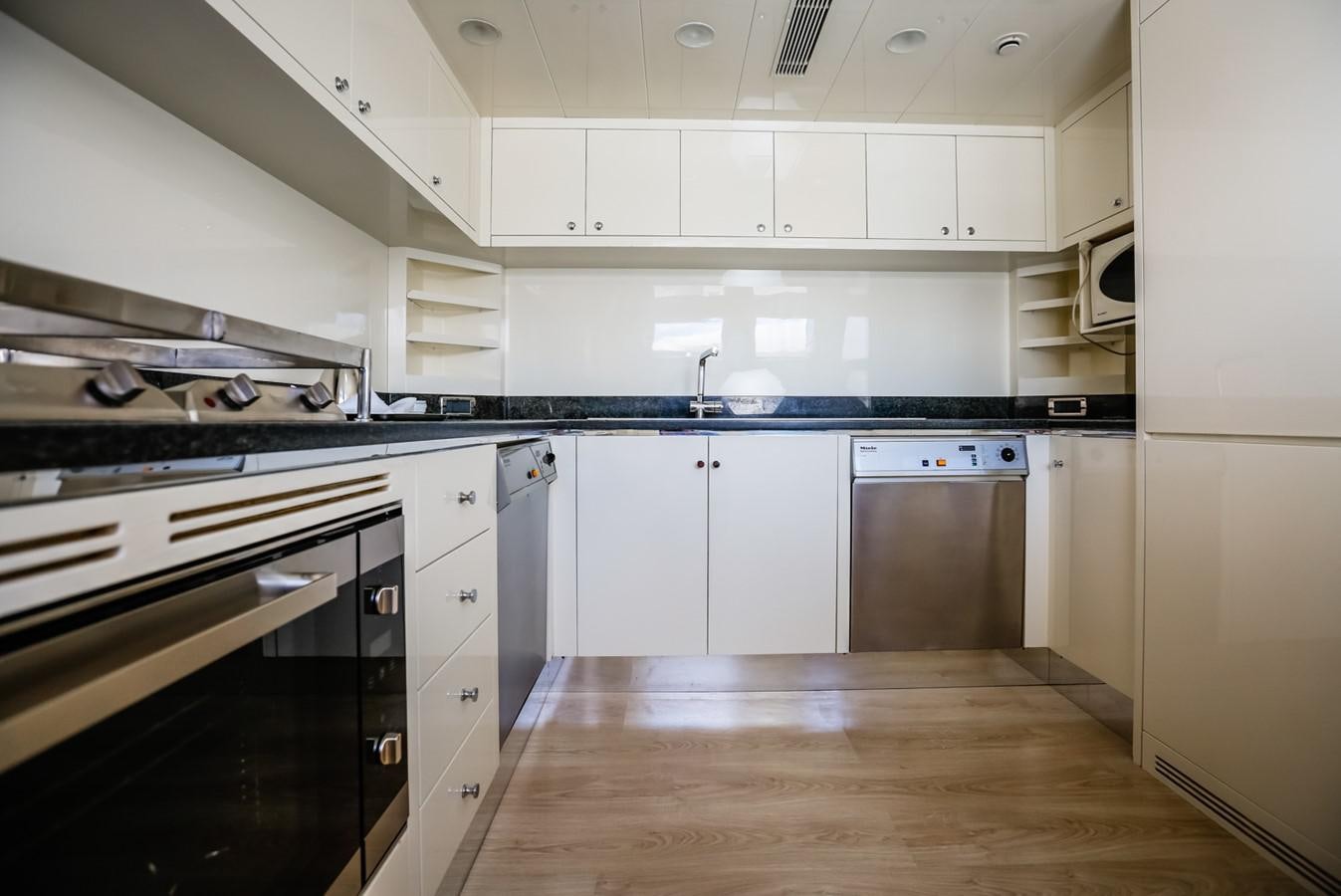 a kitchen with white cabinets aboard HUNTER Yacht for Sale