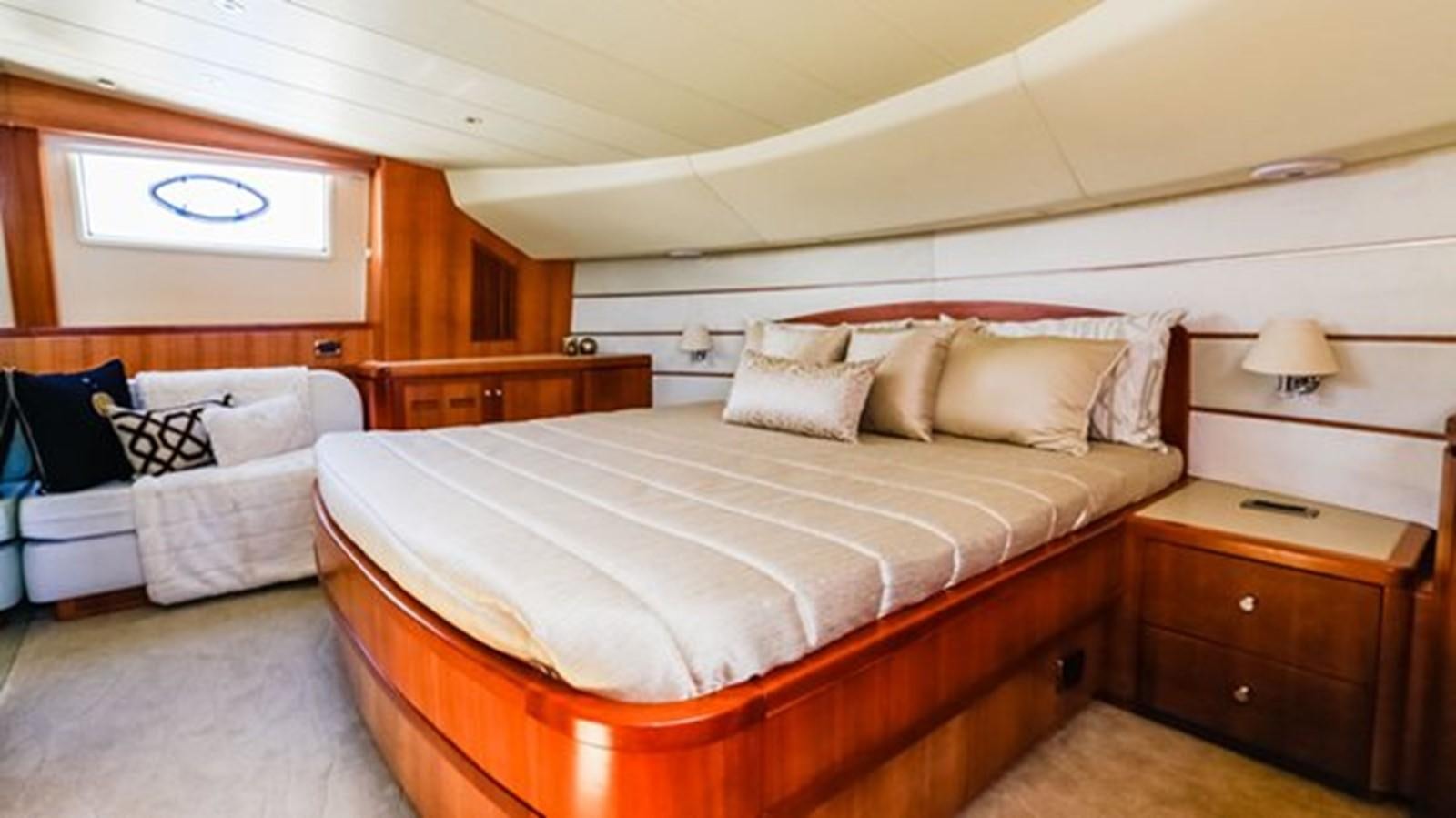 a bedroom with a bed and a dresser aboard HUNTER Yacht for Sale