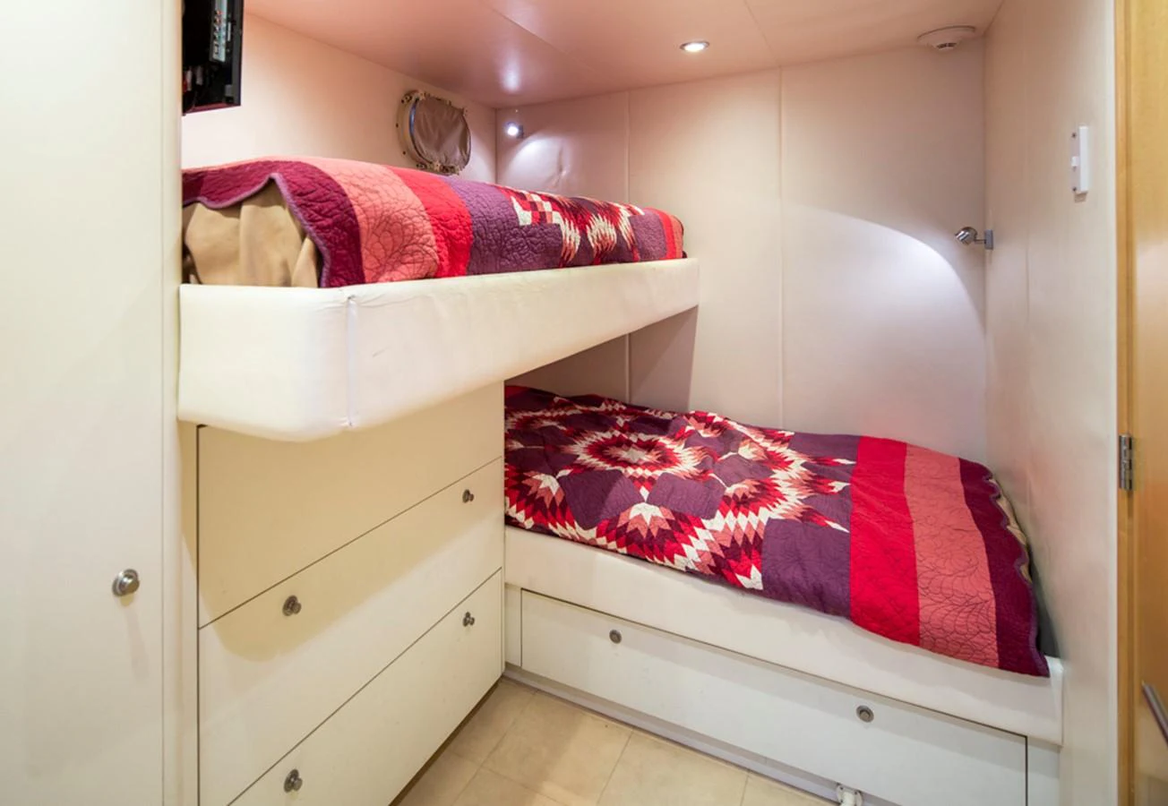 a room with a bed and a dresser aboard C JEWEL Yacht for Sale
