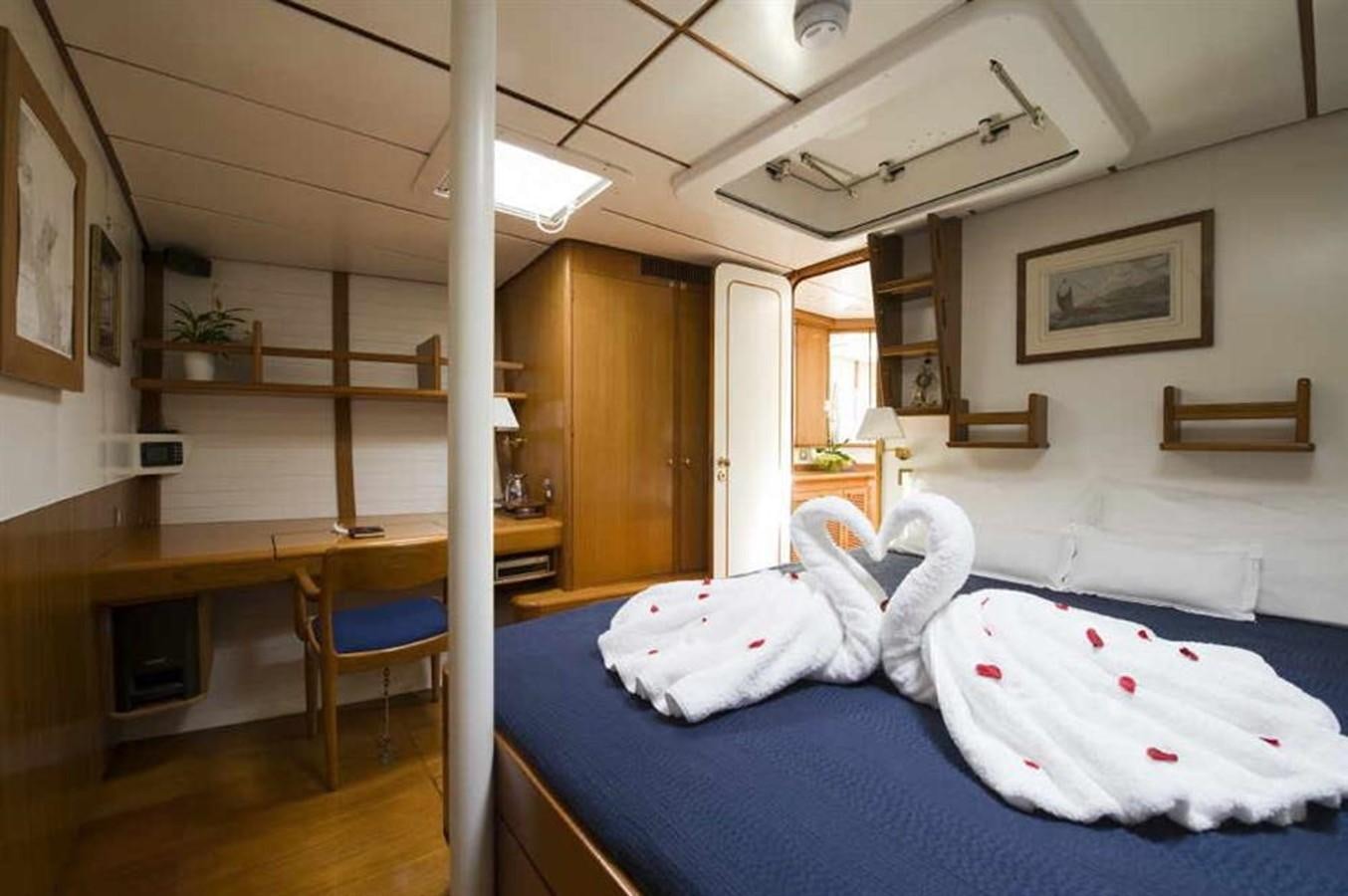 a bedroom with a bed and desk aboard BAIURDO VI Yacht for Sale