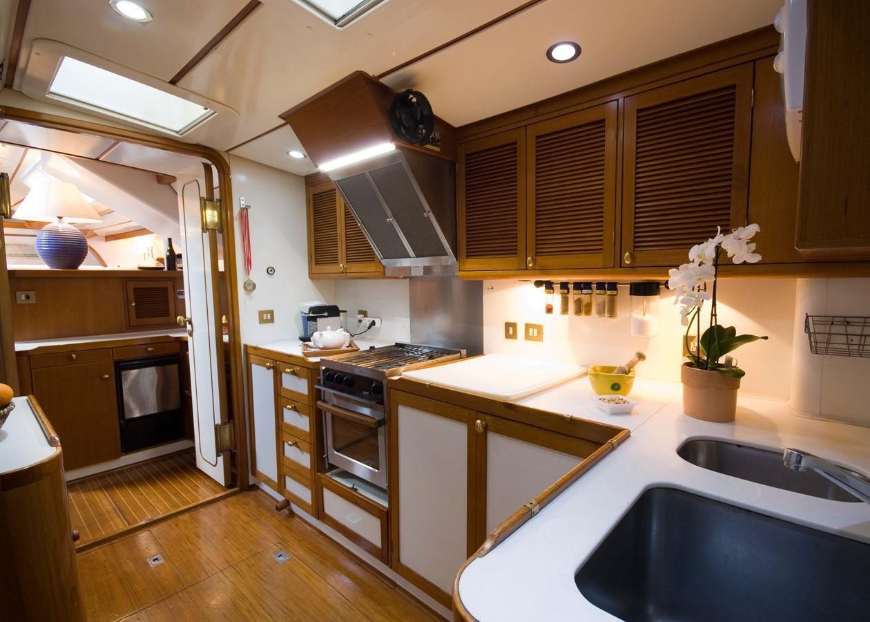 a kitchen with wooden cabinets aboard BAIURDO VI Yacht for Sale