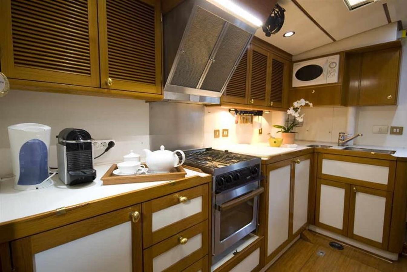 a kitchen with wooden cabinets aboard BAIURDO VI Yacht for Sale