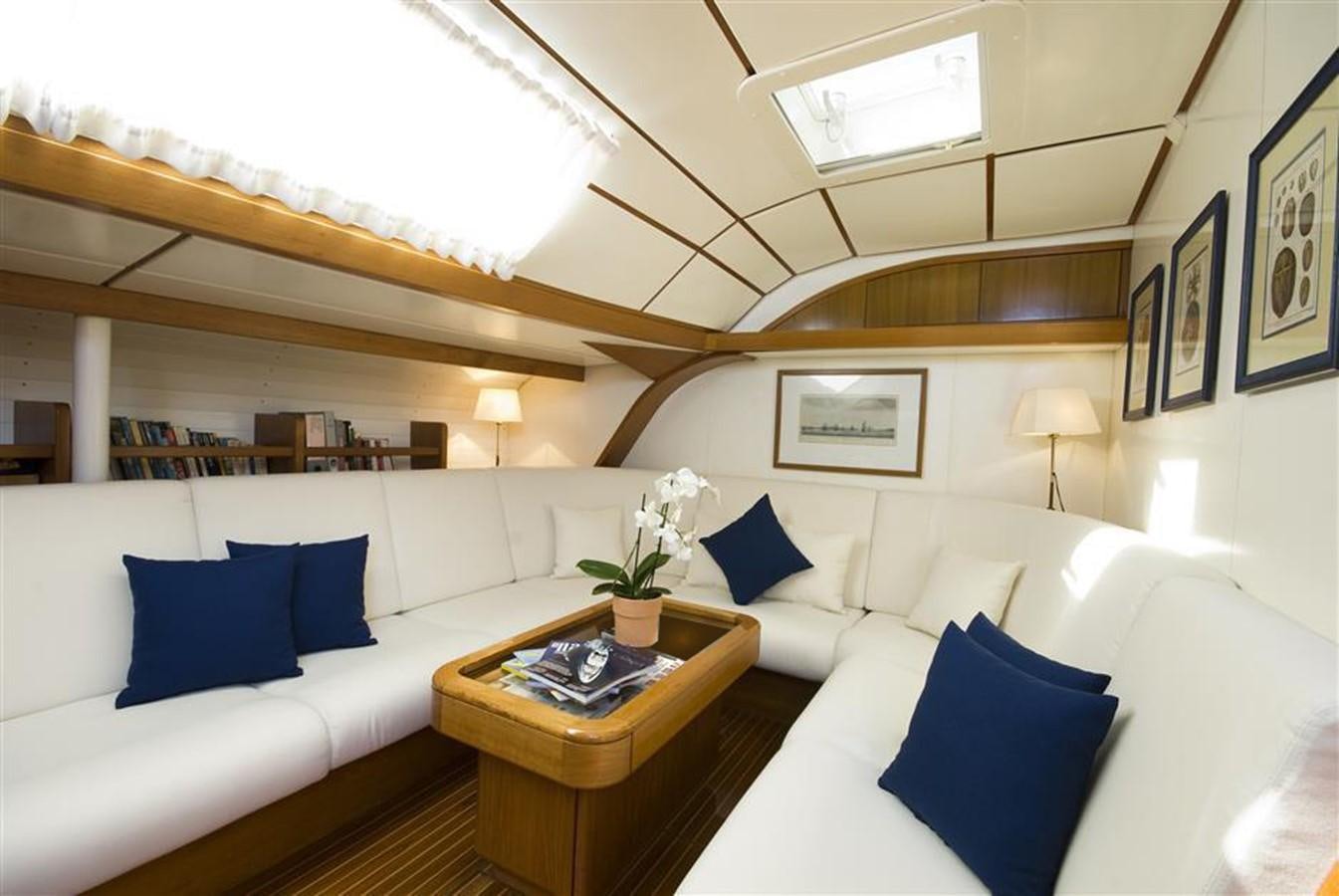 a room with a couch and a table with a lamp on it aboard BAIURDO VI Yacht for Sale