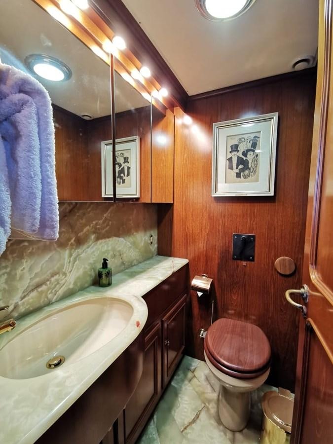 a bathroom with a toilet sink and a mirror aboard BEL AMI II Yacht for Sale