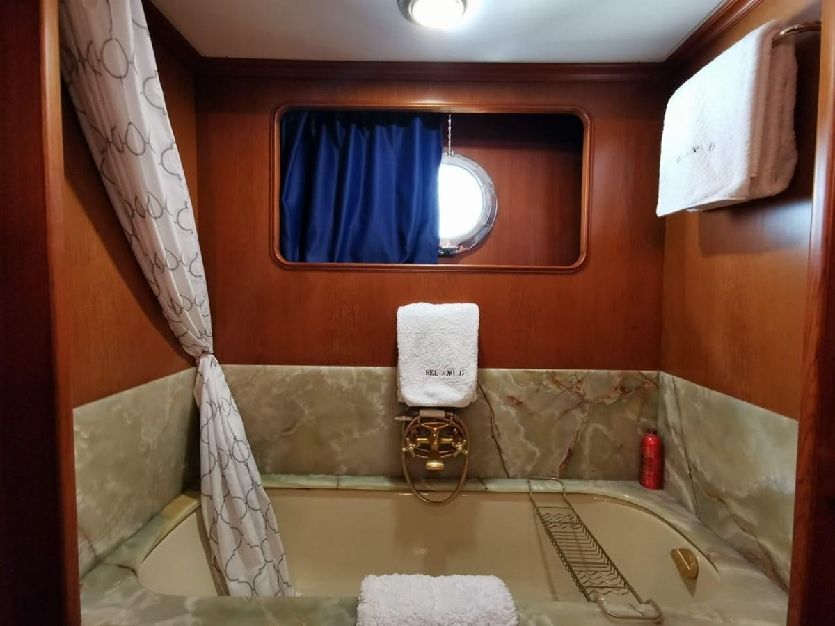 a bathroom with a bathtub and a sink aboard BEL AMI II Yacht for Sale