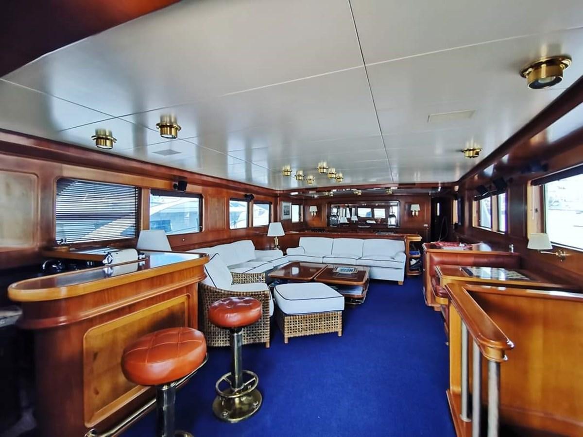 a large kitchen with a bar and seating area aboard BEL AMI II Yacht for Sale