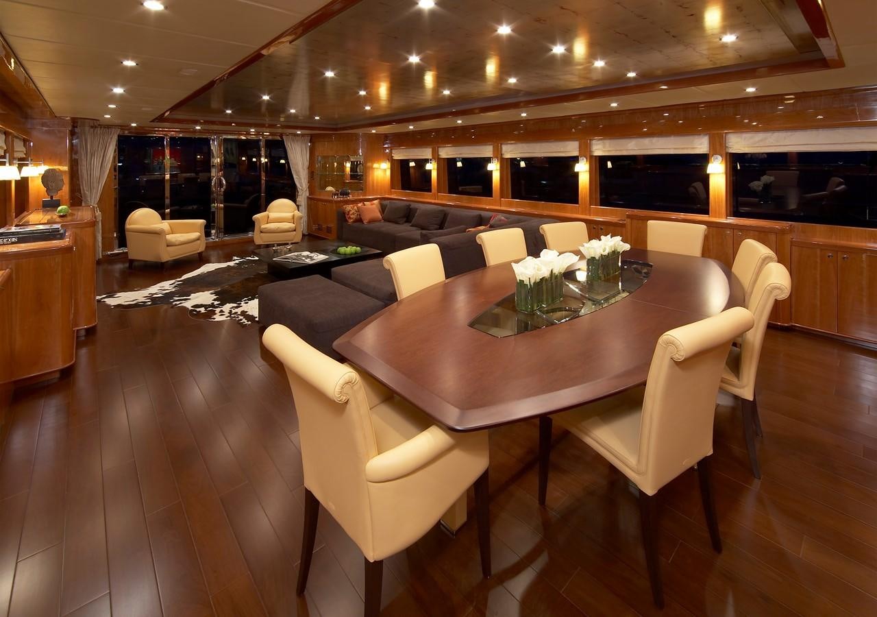 a large room with a table and chairs aboard JOHNSON 110 FLYBRIDGE Yacht for Charter