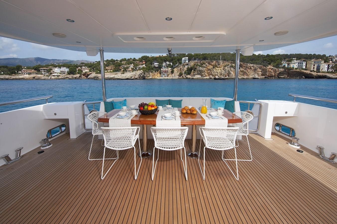 a table set up on a deck overlooking a large body of water aboard JOHNSON 110 FLYBRIDGE Yacht for Charter