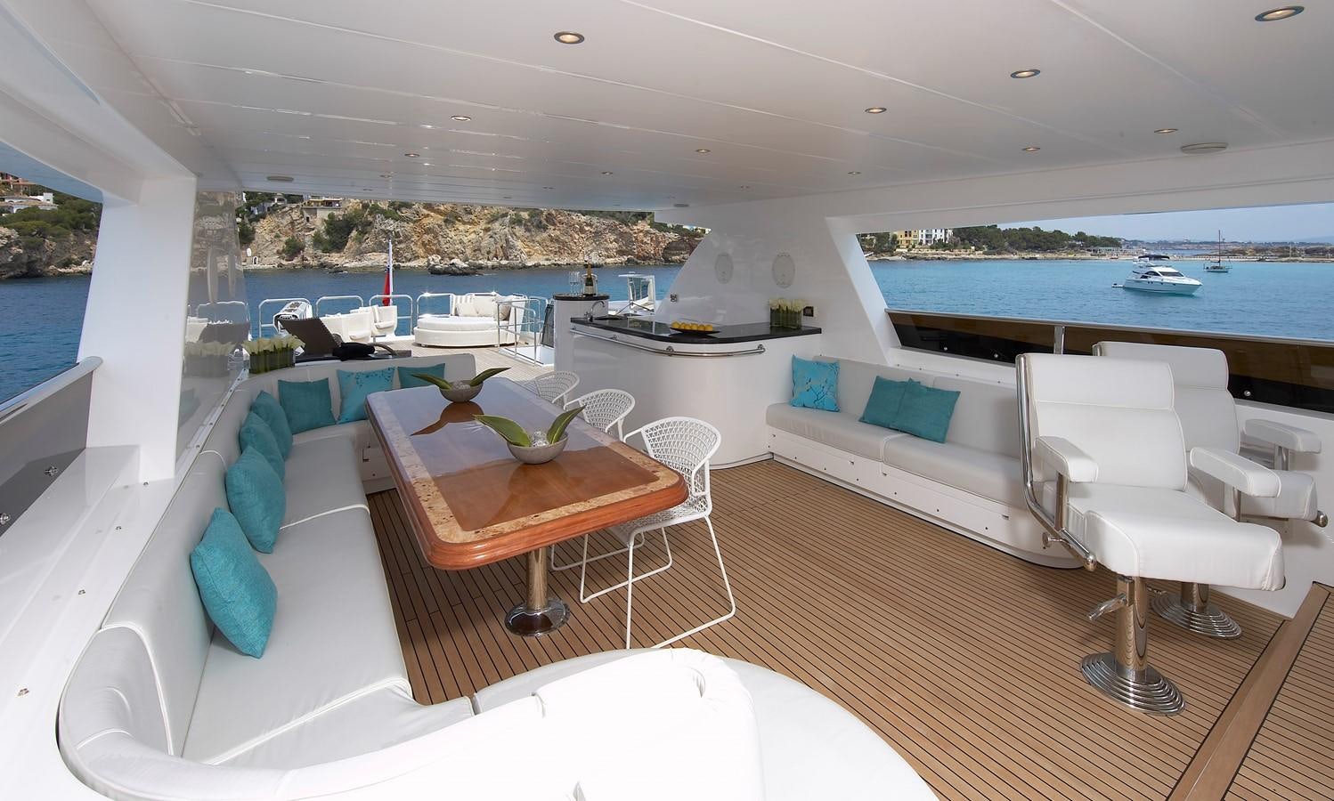a room with a couch and a table and chairs aboard JOHNSON 110 FLYBRIDGE Yacht for Charter