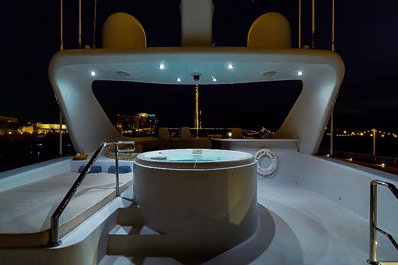 a large outdoor bar with a large round table and chairs aboard IDLETYME II Yacht for Sale