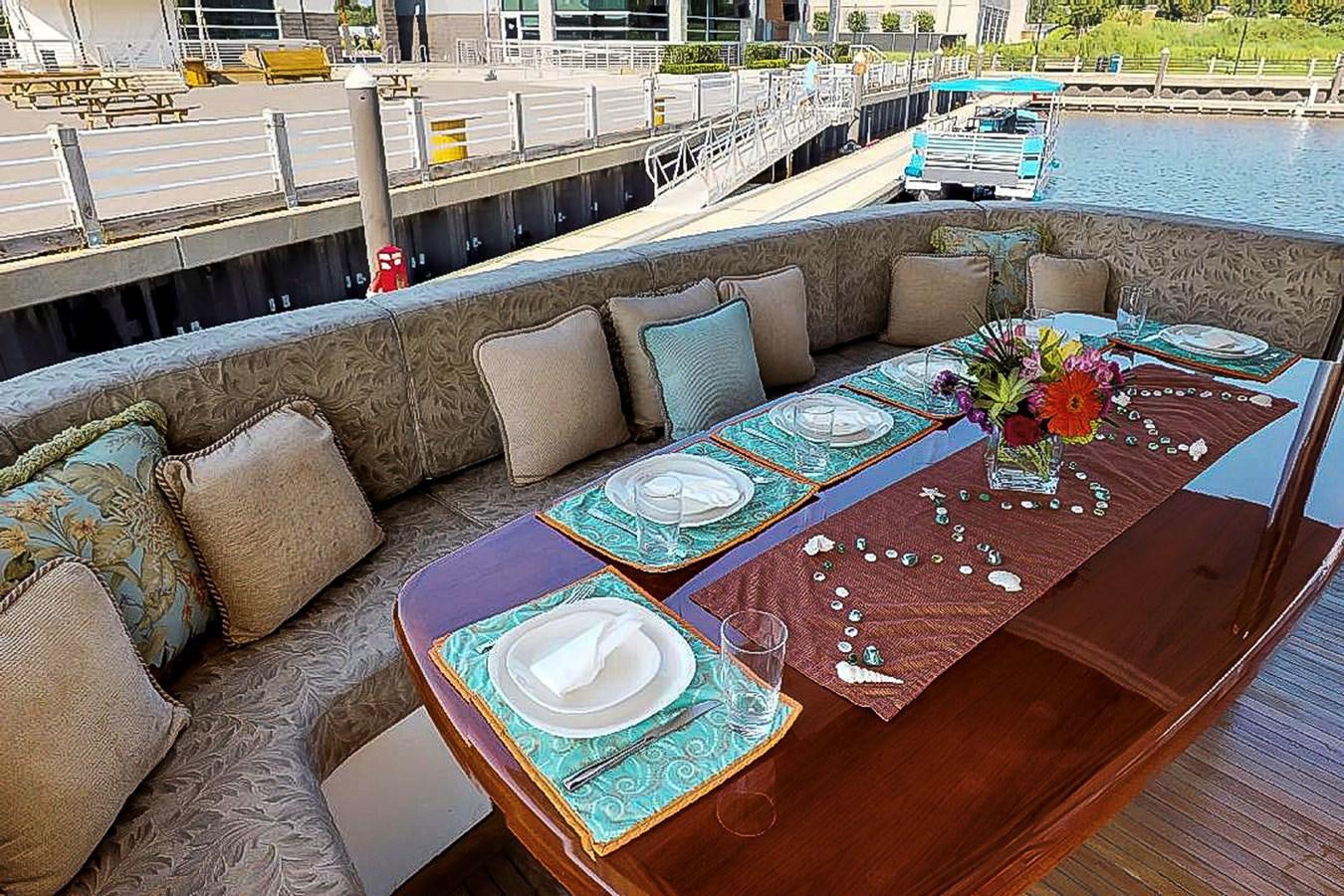 a table with pillows and a couch aboard IDLETYME II Yacht for Sale