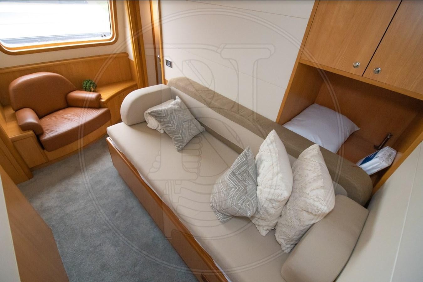 a bed with pillows and a chair aboard ANGELE Yacht for Sale
