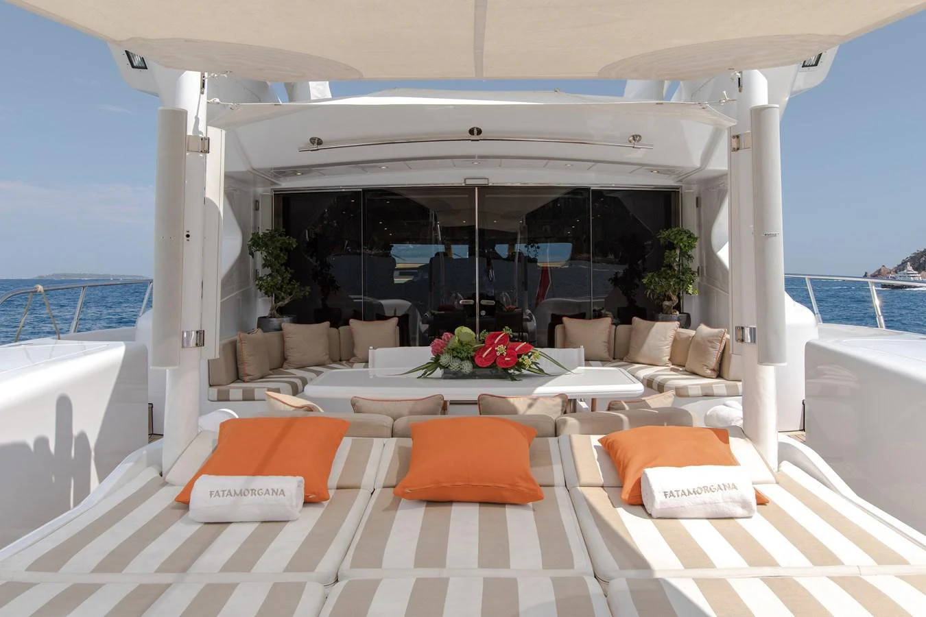 a large white lounge area with a large white lounge chair and a large window with a view of aboard FATAMORGANA Yacht for Sale