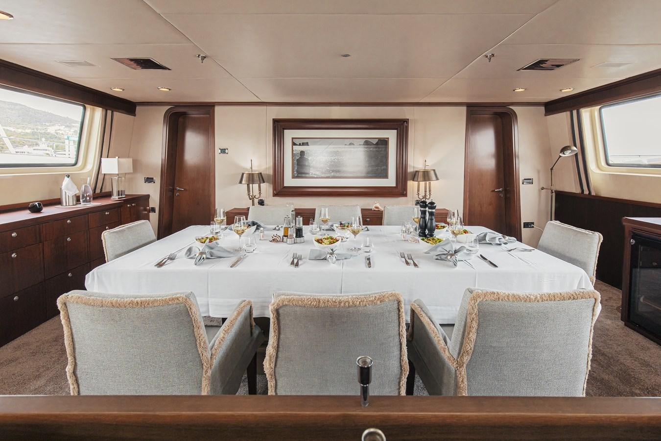 a large dining table with a large white tablecloth aboard XO OF THE SEAS Yacht for Sale