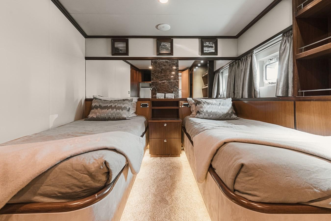 a room with a bed and a dresser aboard XO OF THE SEAS Yacht for Sale